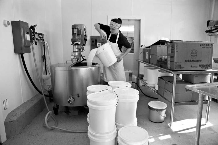 Hannah Bath pouring milk into a heating unit.