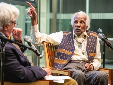 Ashley Bryan, right, gestures while speaking about his work at an event at the University of Pennsylavnia.