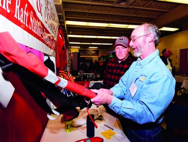 Josh Spearing looks at different kinds of PFDs at the Maine Fishermen's Forum.