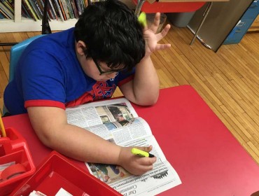 Wyatt, a student on the Cranberry Isles, uses the newspaper to highlight words with the "ch" and "th" sounds.