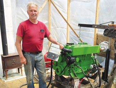 Chris Rich poses with the engine he rebuilt.