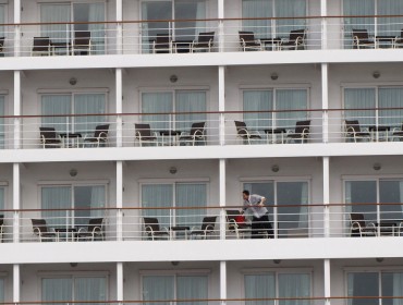 A crew member cleans windows on a cruise ship calling in Portland in 2014.