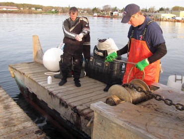 Lucas Fields, left, dons a dry suit as Dallas Fields prepares a chain.