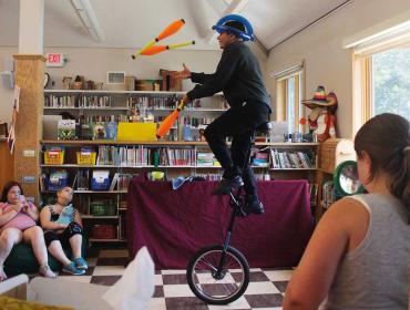 Zach Field wows the crowd as he juggles and rides a unicycle.