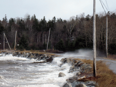 Seas break over the main road on the Narrows in Islesboro.