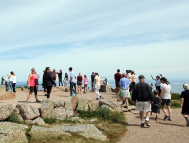 Visitors walk atop Cadillac Mountain, which is accessible by car.