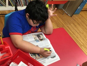 Wyatt, a student on the Cranberry Isles, uses the newspaper to highlight words with the "ch" and "th" sounds.