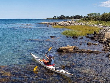 A kayaker explores one of the islands on the Maine Island Trail.