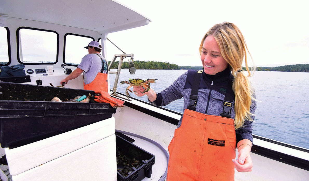 Quahog Bay Conservancy staff Alec Bolinger, a former fisherman (at the helm), and Nicole Twohig, Development Coordinator, harvest green crabs from 100 traps in Quahog Bay. 