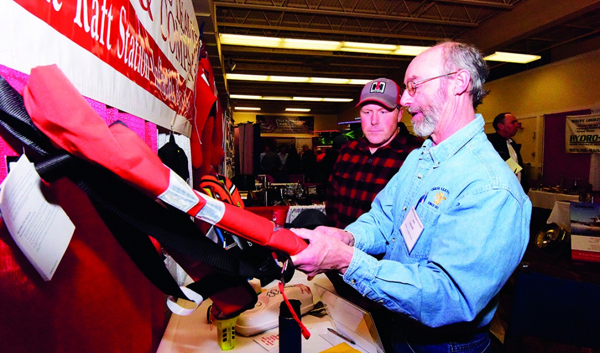 Josh Spearing looks at different kinds of PFDs at the Maine Fishermen's Forum.