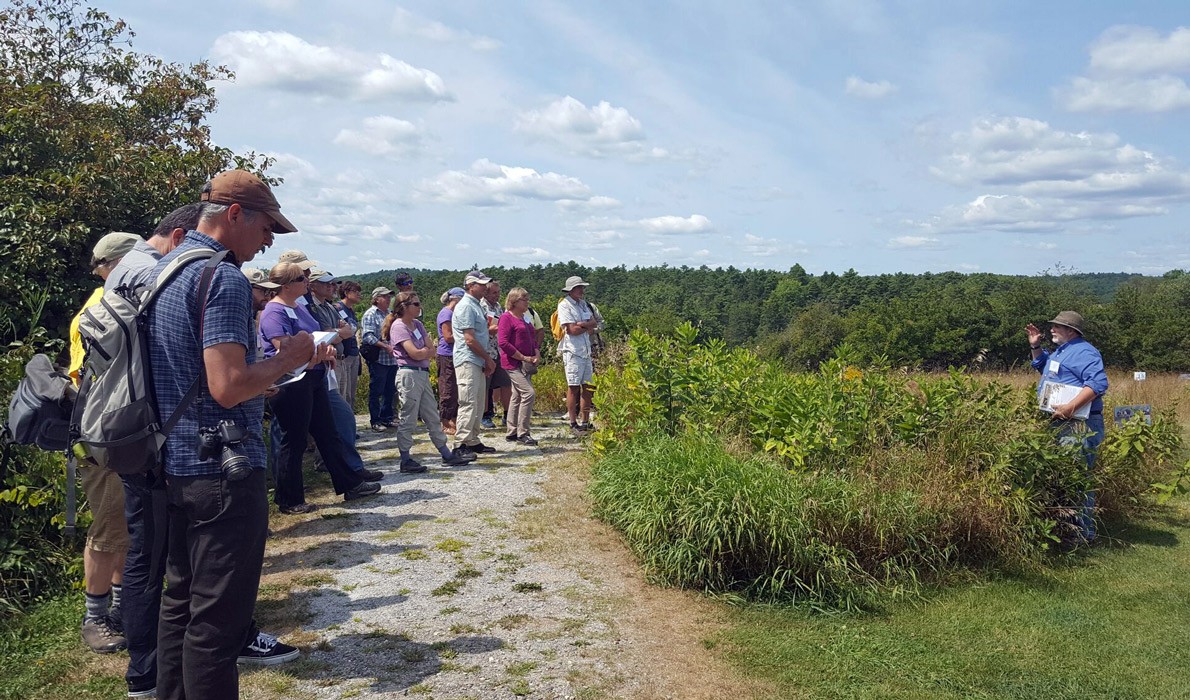 Conference attendees at Whaleback Shell Midden Historic Site in Damariscotta listen to Arthur Spiess, a senior archaeologist with Maine Historic Preservation. 