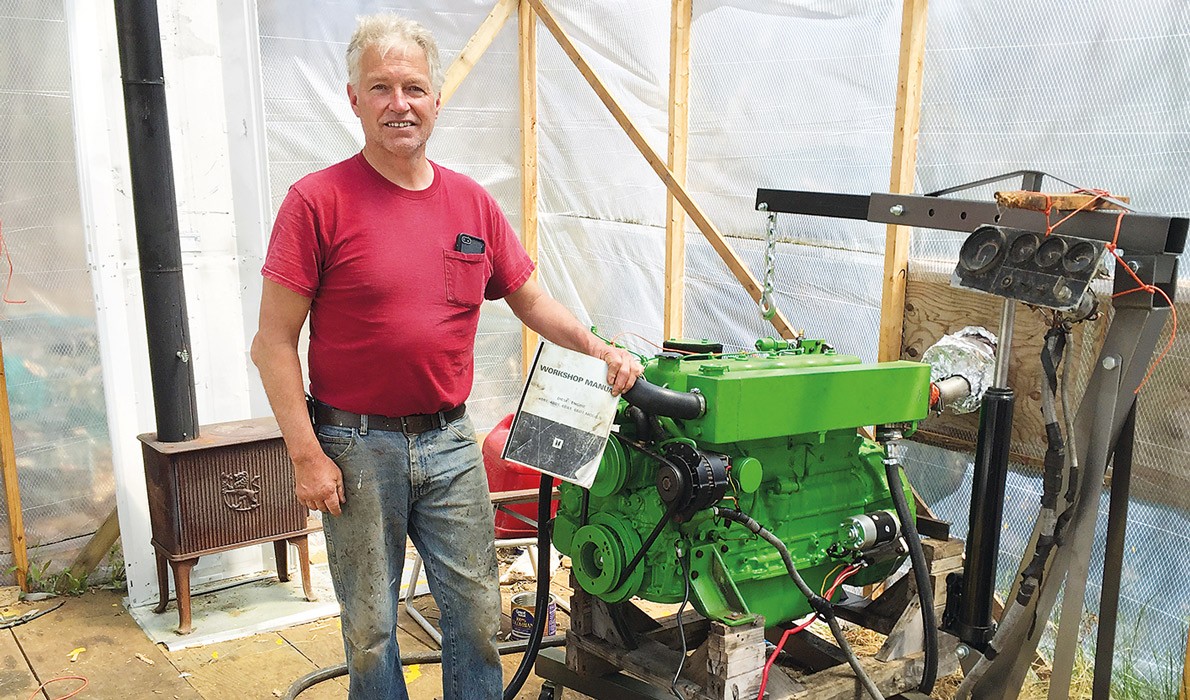 Chris Rich poses with the engine he rebuilt.