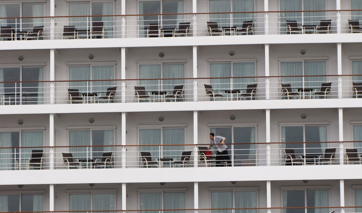 A crew member cleans windows on a cruise ship calling in Portland in 2014.