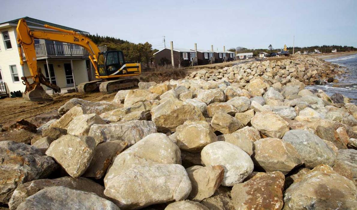 An excavator works to repair a seawall at Popham Beach.