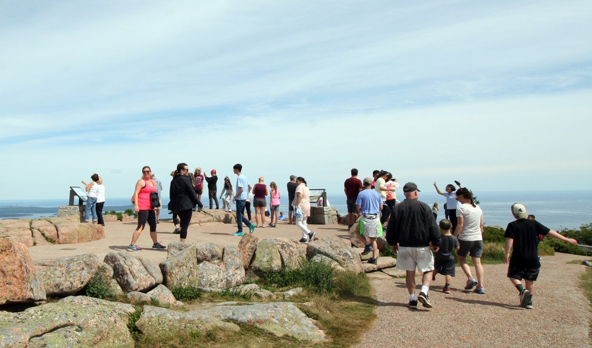 Visitors walk atop Cadillac Mountain, which is accessible by car.