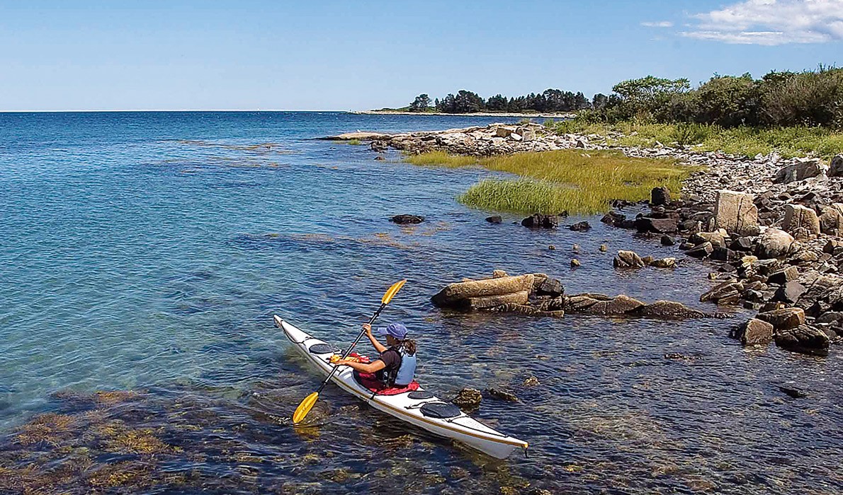 A kayaker explores one of the islands on the Maine Island Trail.