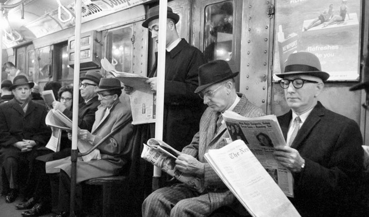 reading newspapers on the subway